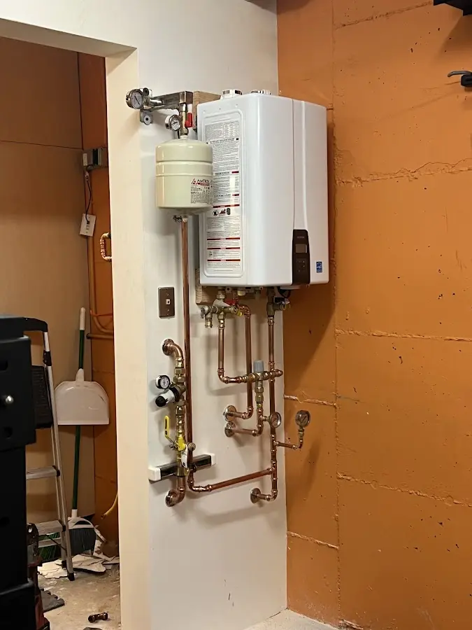 Plumbing technician inspecting water heater connections in Peninsula